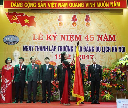 Thừa ủy quyền của Phó Chủ tịch nước CHXHCN Việt Nam Đặng Thị Ngọc Thịnh, Thứ trưởng Bộ VHTTDL Đặng Thị Bích Liên gắn Huân chương lao động hạng Nhì lên lá cờ truyền thống của Nhà trường.